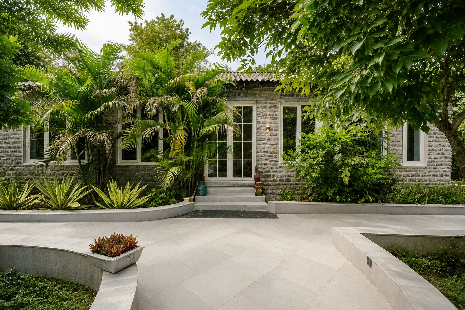 Palm-lined walkway and stone cottages at Godward Luxury Retreat, Jawai